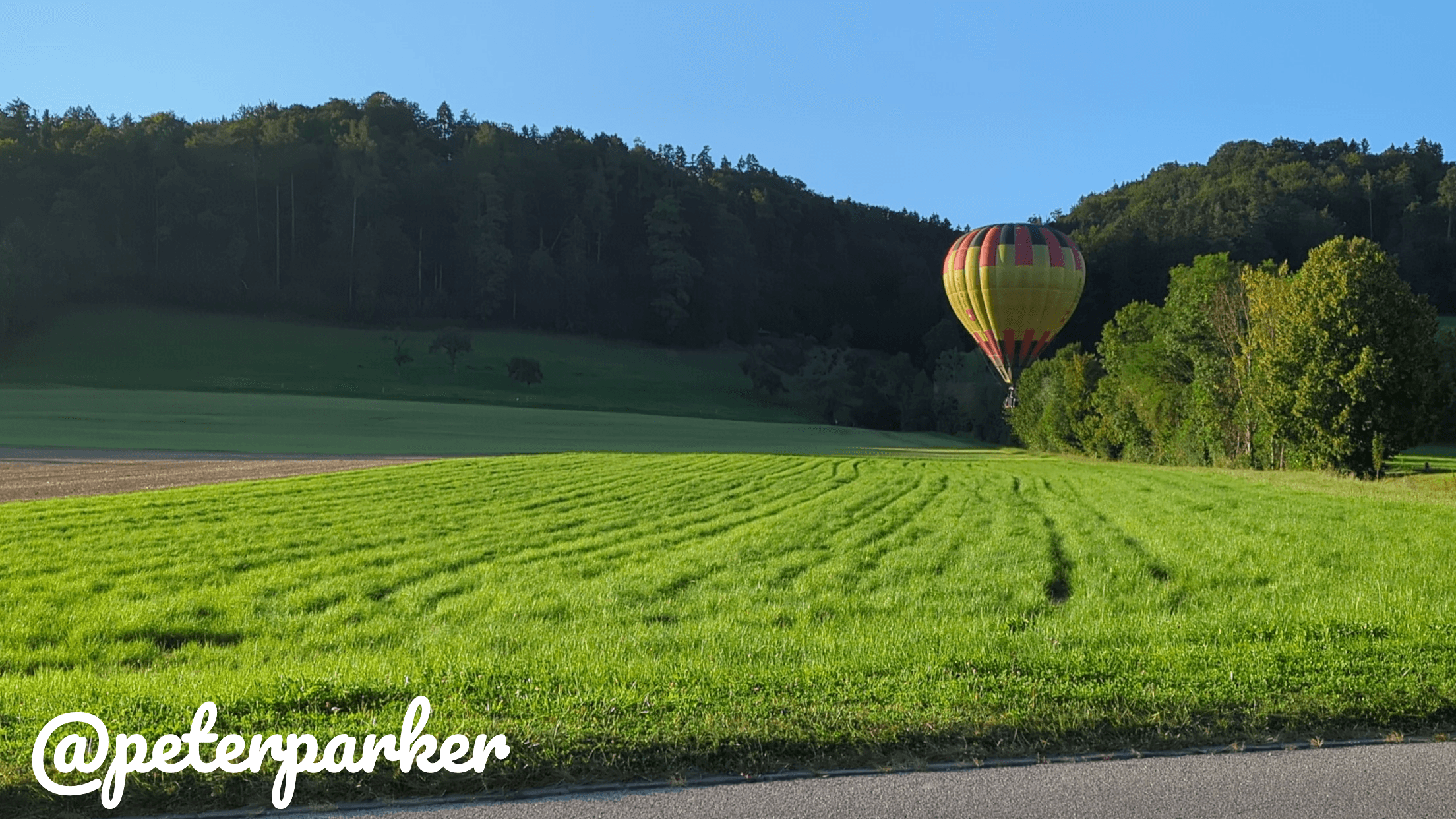 An example picture of a hot air balloon on a field with a text watermark in the Pacifico font.