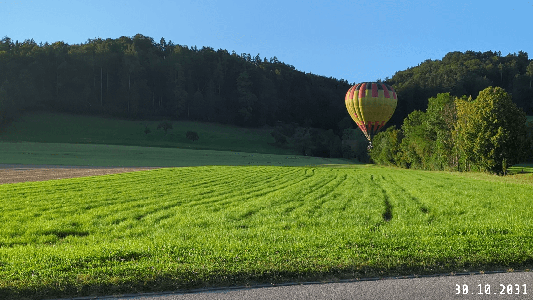 An example picture of a hot air balloon on a field with a date watermark in the Share Tech Mono font.